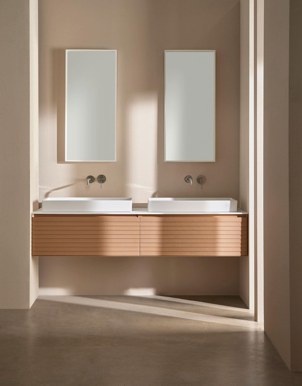 Mueble de baño Banaavat en color marrón claro con parte superior en color blanco. Dos lavabos con grifería de plata empotrada y espejos rectangulares.
