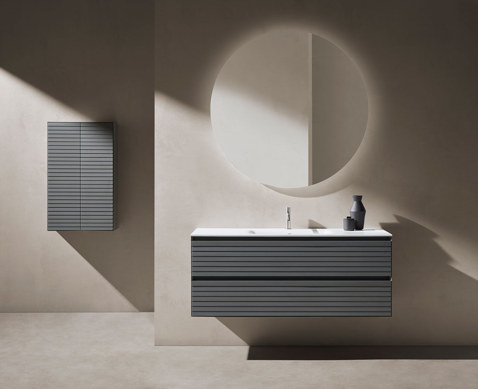 Mueble de baño Osnovan parte superior en blanco y parte inferior en negro con textura. Espejo circular con grifería en plata.