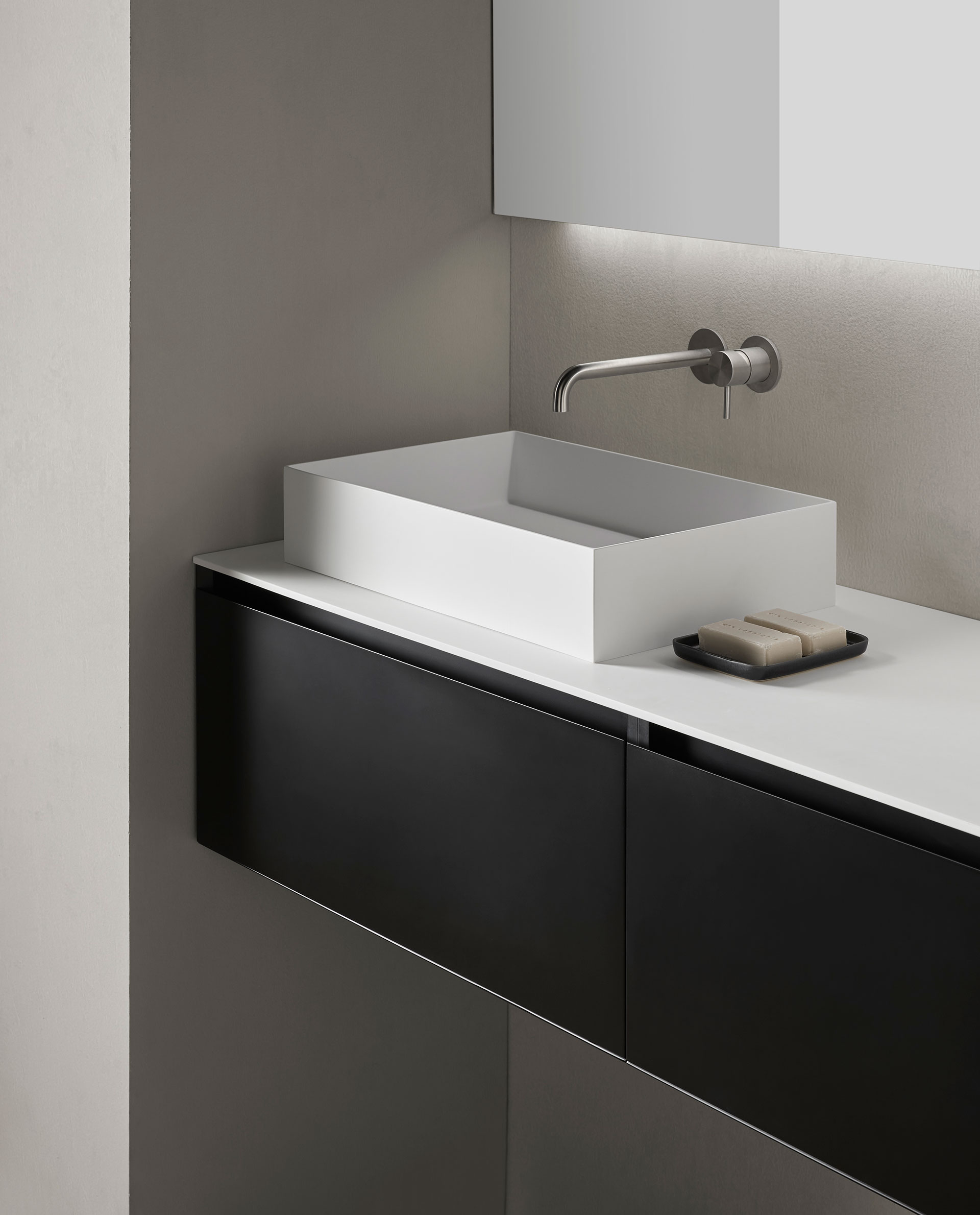 Detalle mueble baño Prim con superficie en blanco y parte frontal con cojones en negro